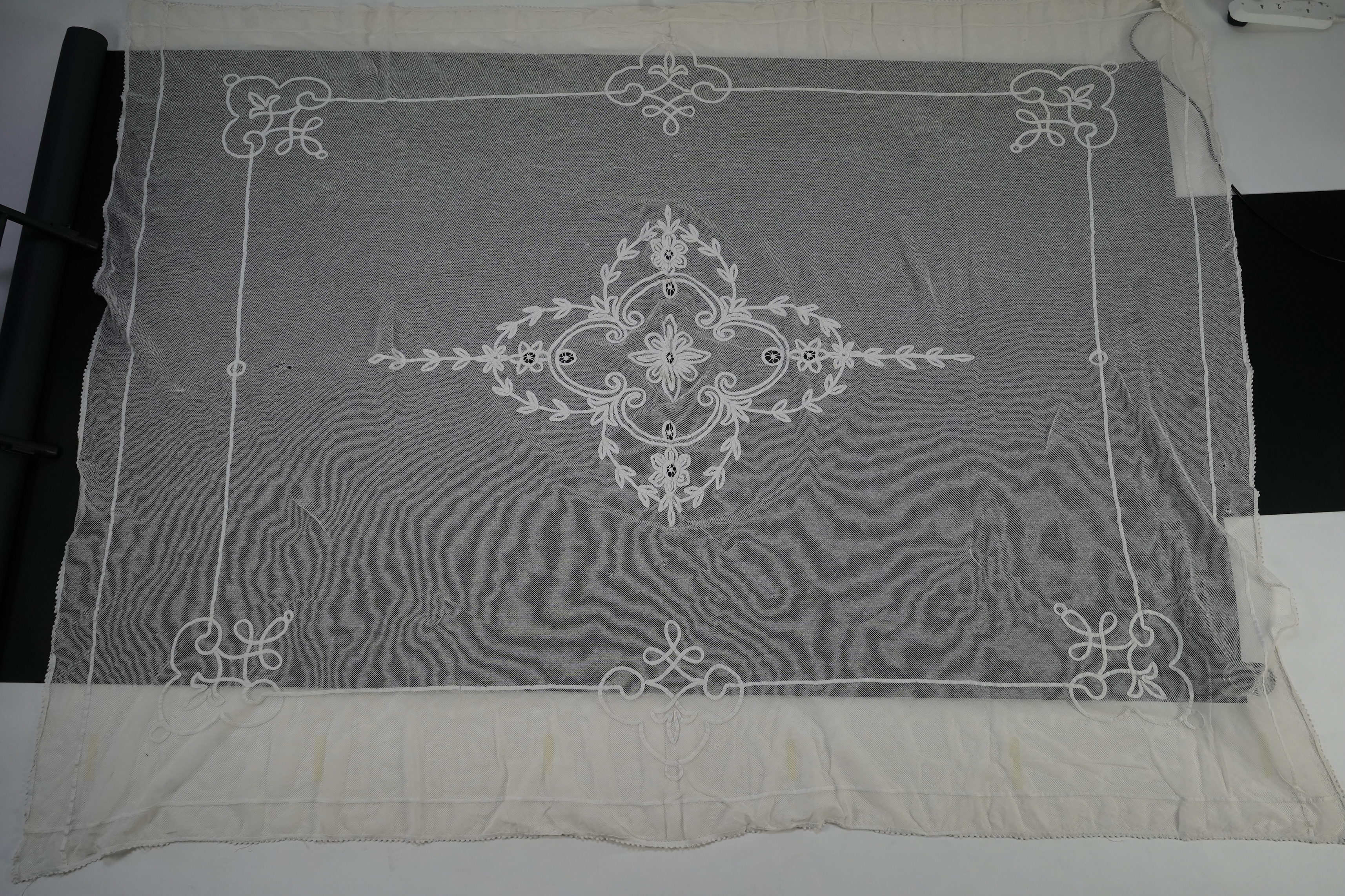 A white tape lace on net bed cover, a cream lace needle run panel, three Brussels bobbin lace collars, a lappet and two beaded tea pot covers, bed cover 200cm x 250cm. Condition - the bedcover has damage to the netting,